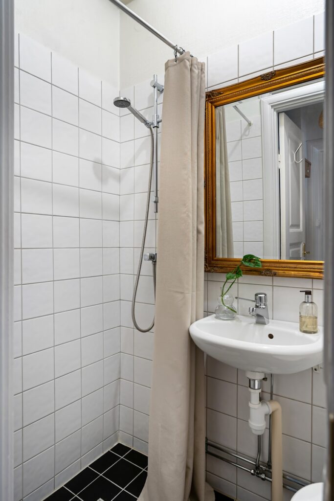A bathroom with a sink, mirror, and shower