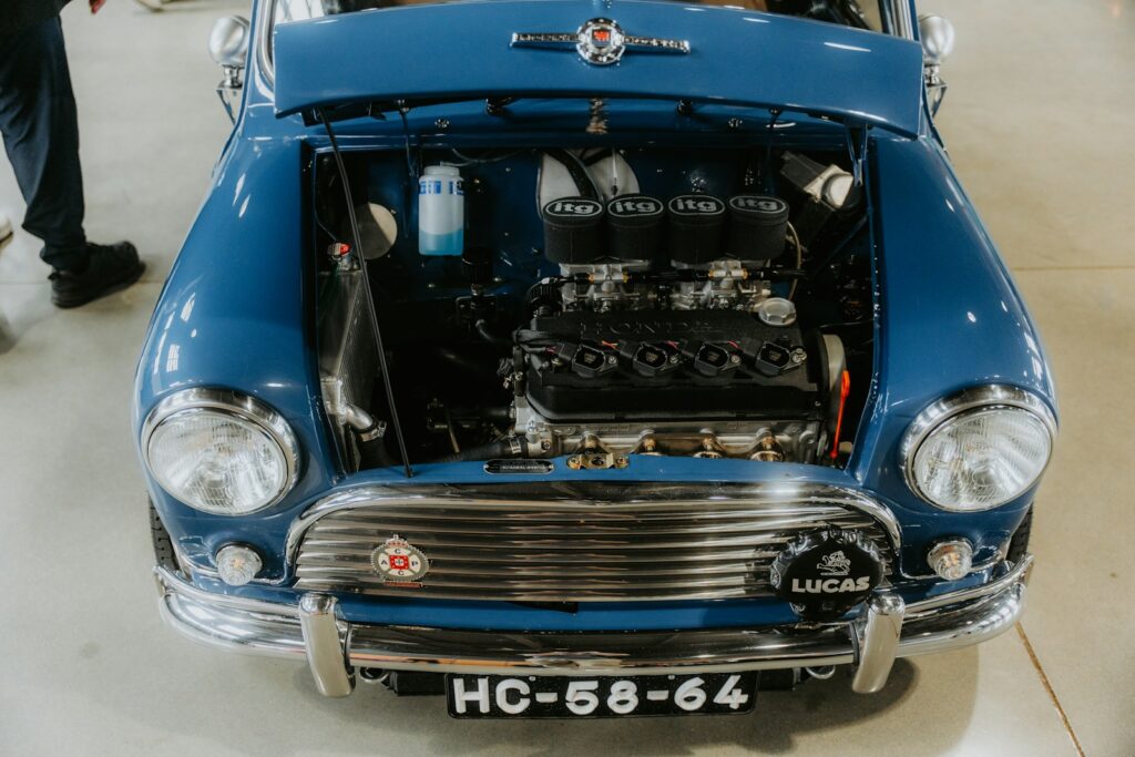 Blue classic car with its hood open.