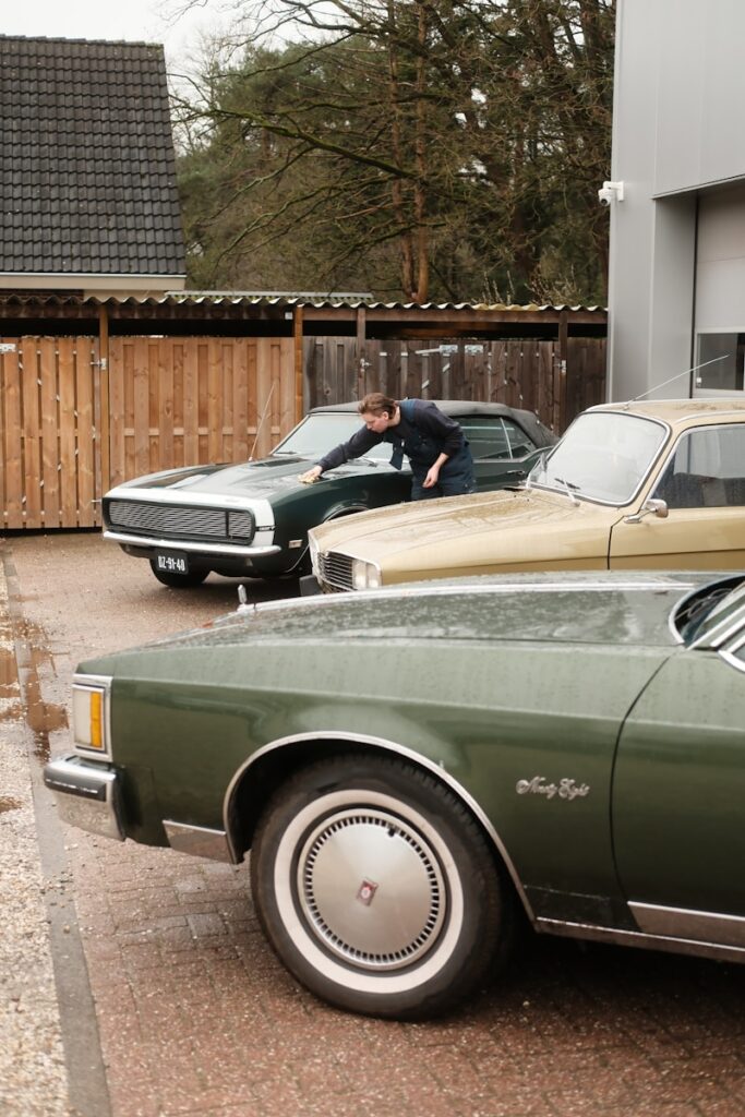 a man leaning on a car in a parking lot