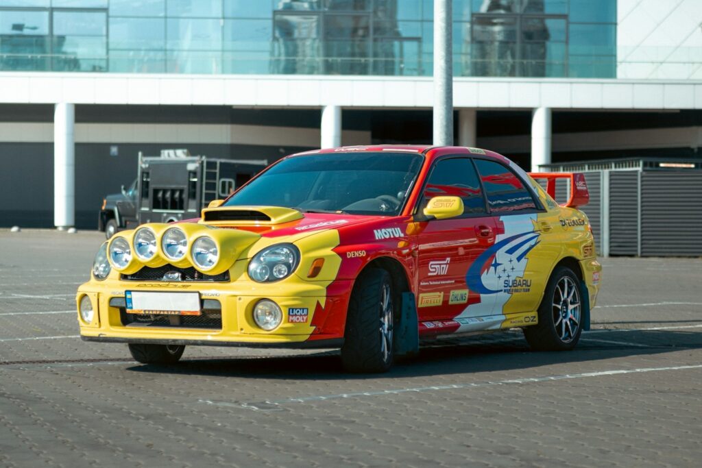 Colorful rally car parked in front of modern building