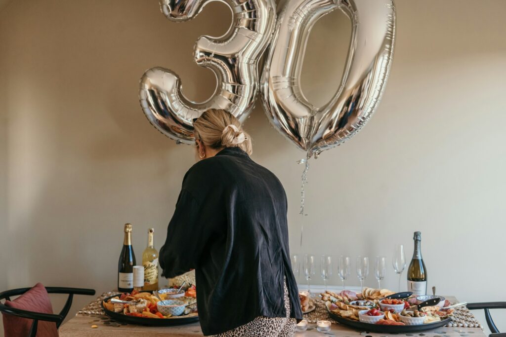 a person standing in front of a table with food and wine bottles