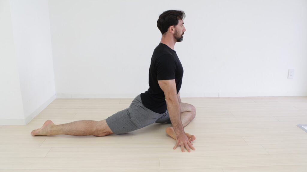 a man sitting on the floor doing a yoga pose