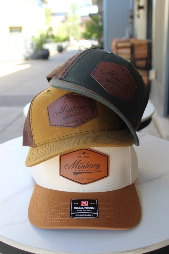 Three hats with "monterey" logos are stacked.