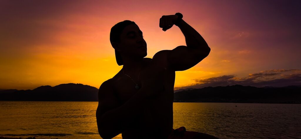 a man holding a bottle of water in front of a sunset