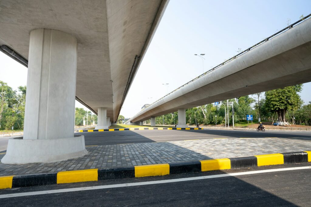 a man riding a bike down a street under a bridge