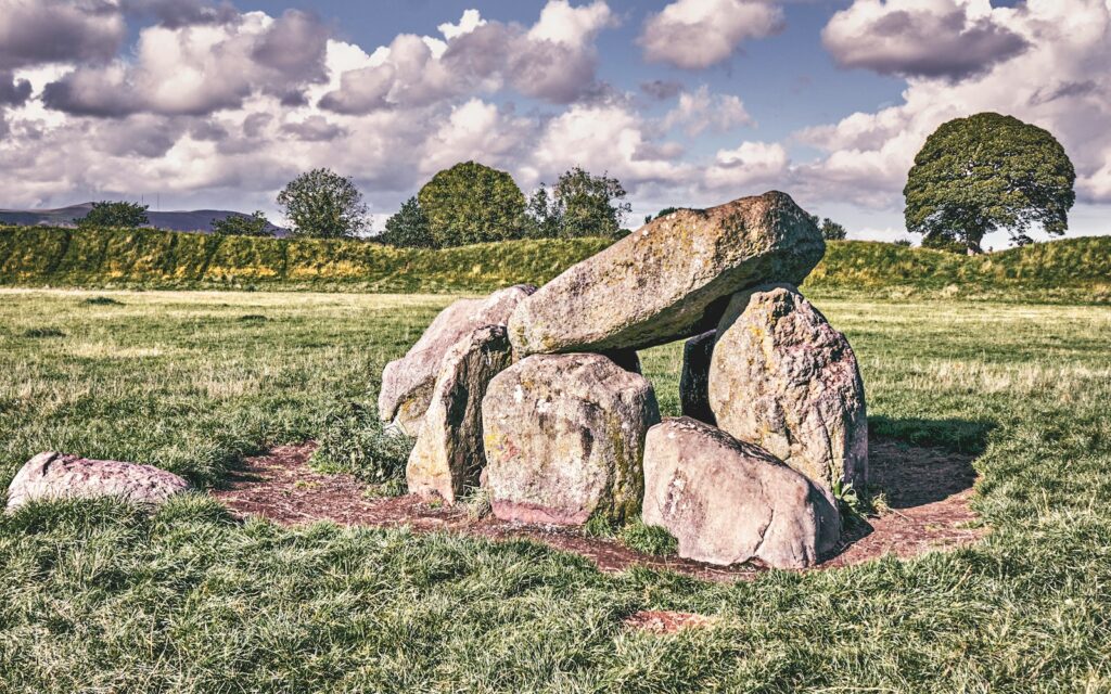 a group of men sitting on a rock in the middle of a field
