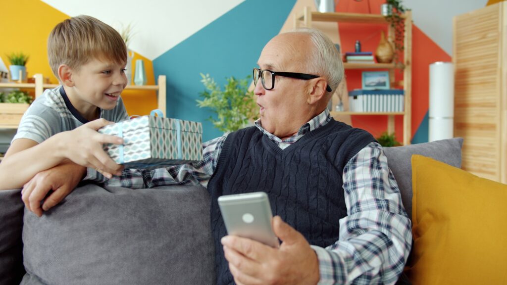 Boy gives surprised grandfather a gift