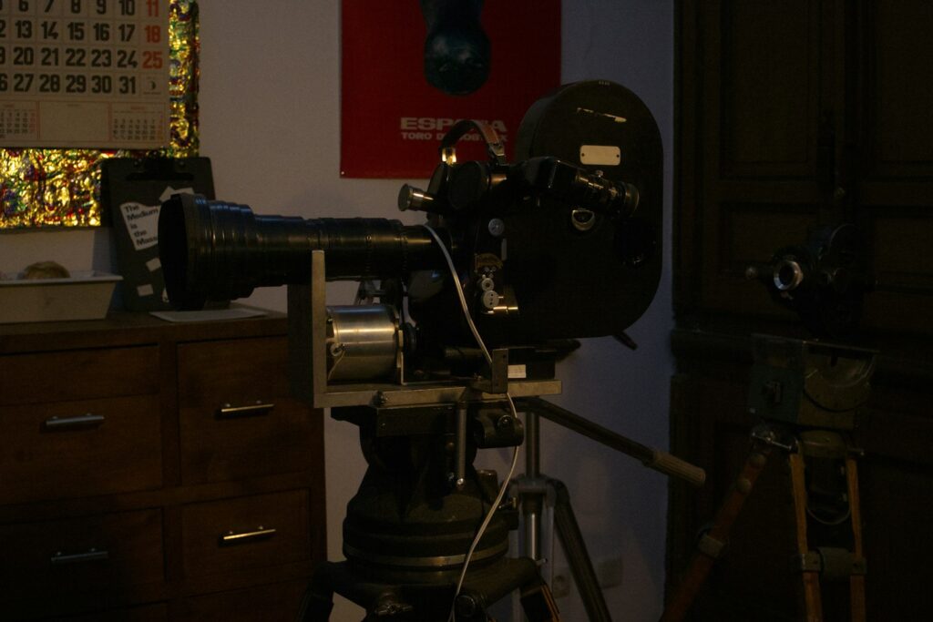 Vintage film camera on tripod in a dimly lit room.