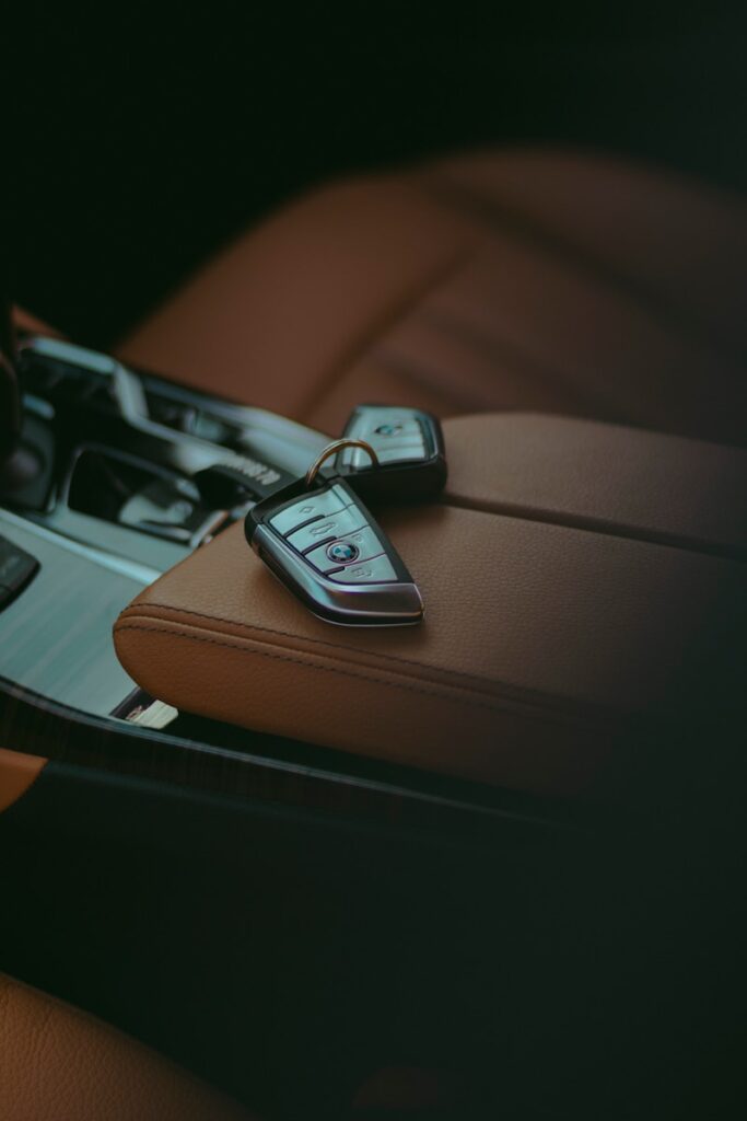 Car keys resting on a leather car seat.