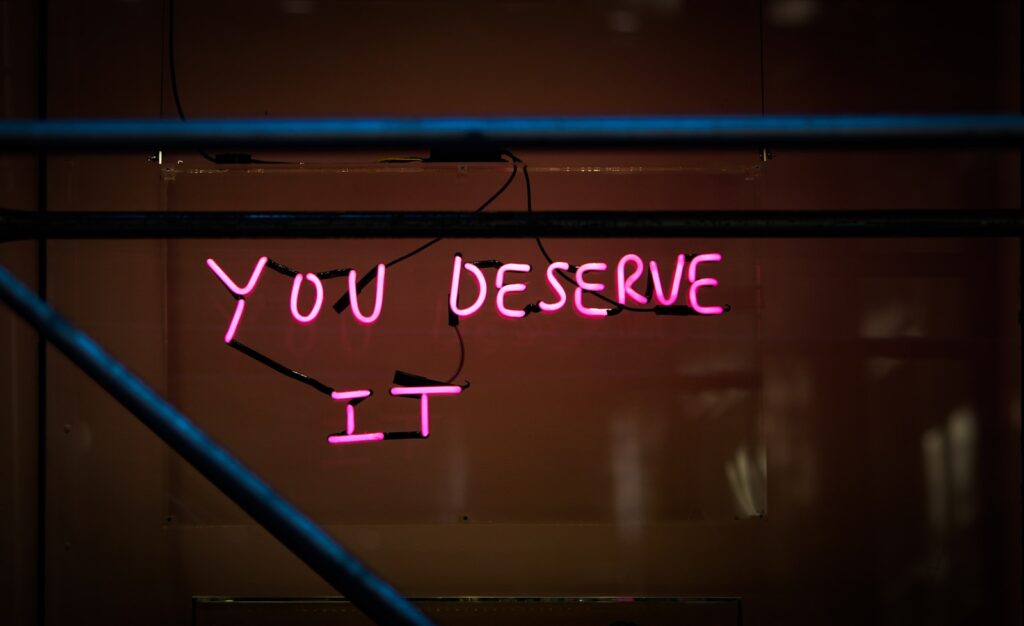 a neon sign that says you deserves it