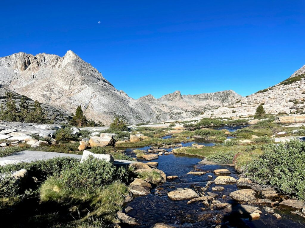 a stream running through a rocky mountain valley