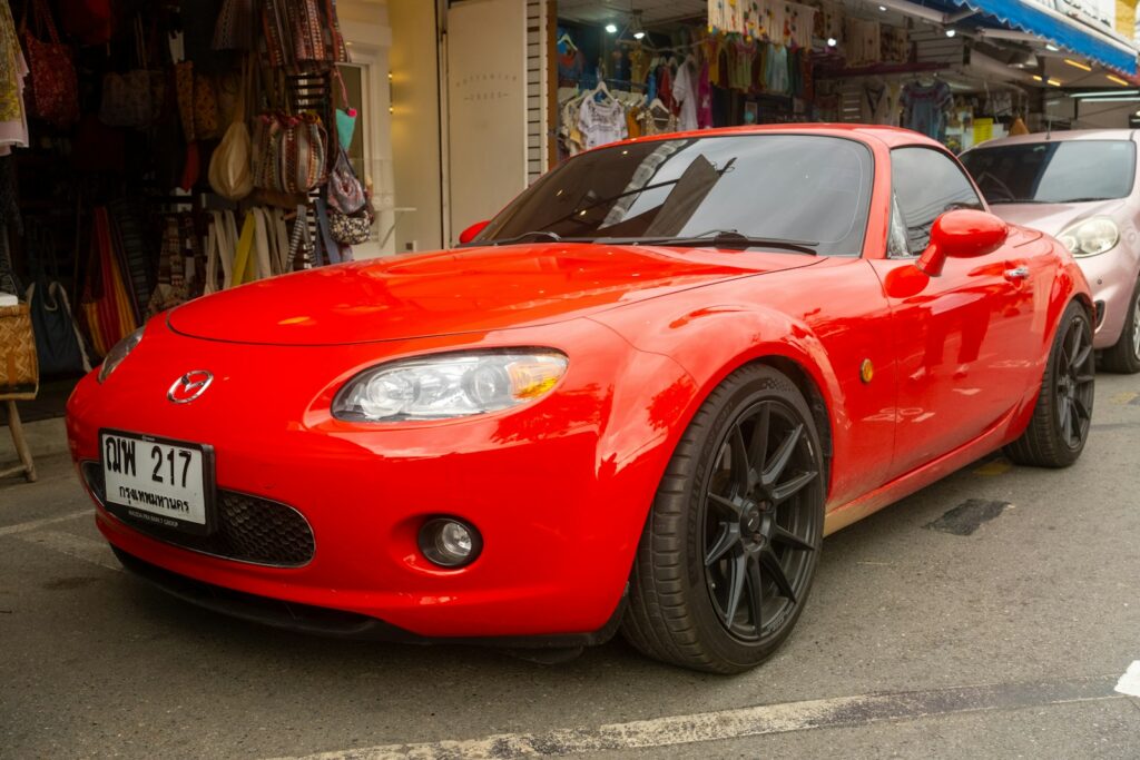A red sports car parked in front of a store