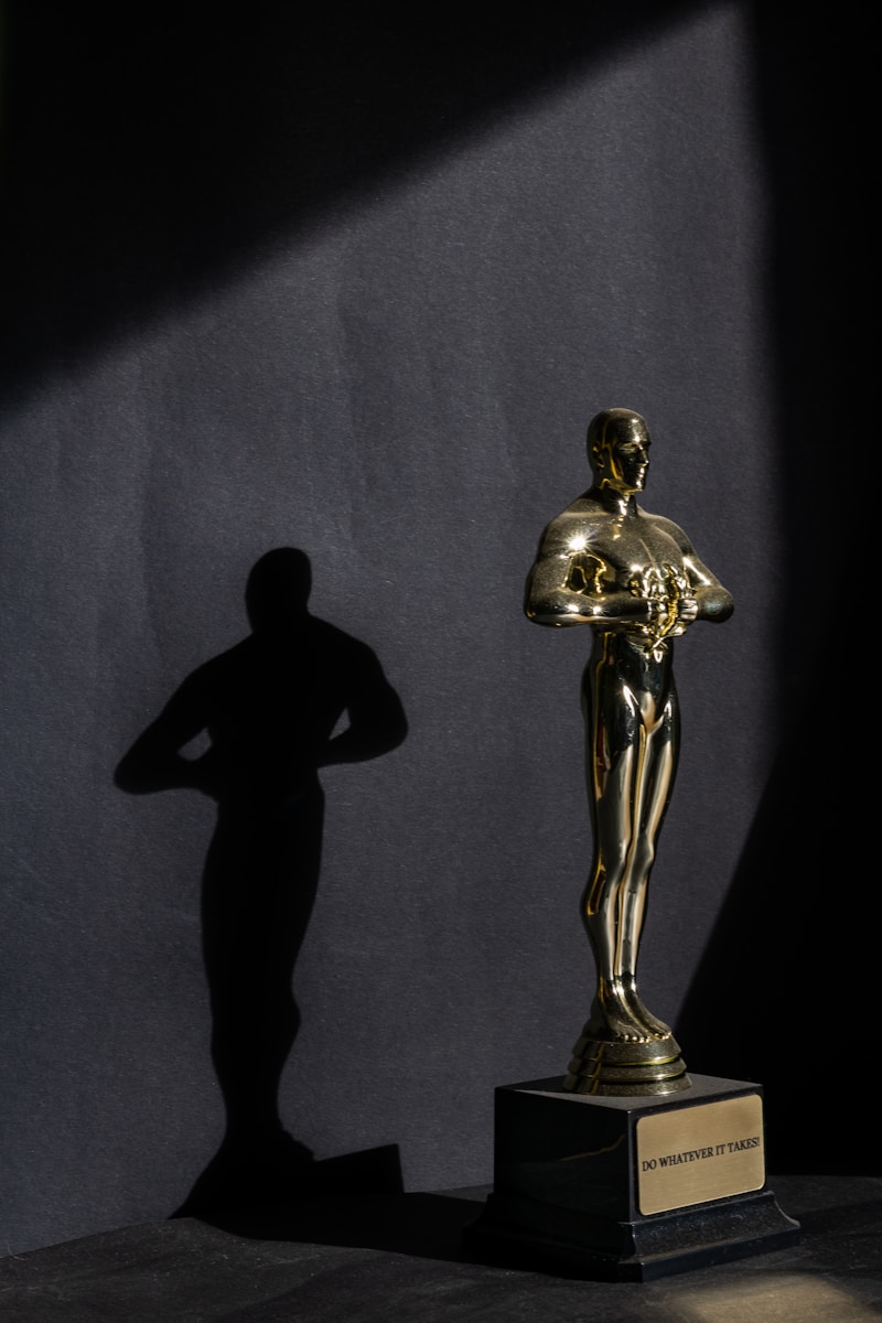 a golden statue of a man standing next to a black wall