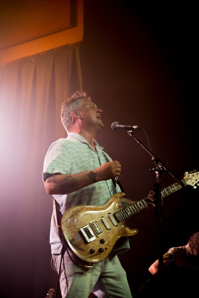 A man standing on a stage with a guitar