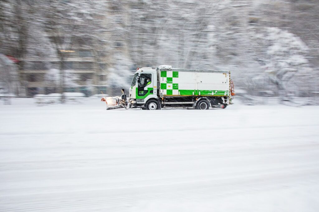 green truck on snow covered road during daytime