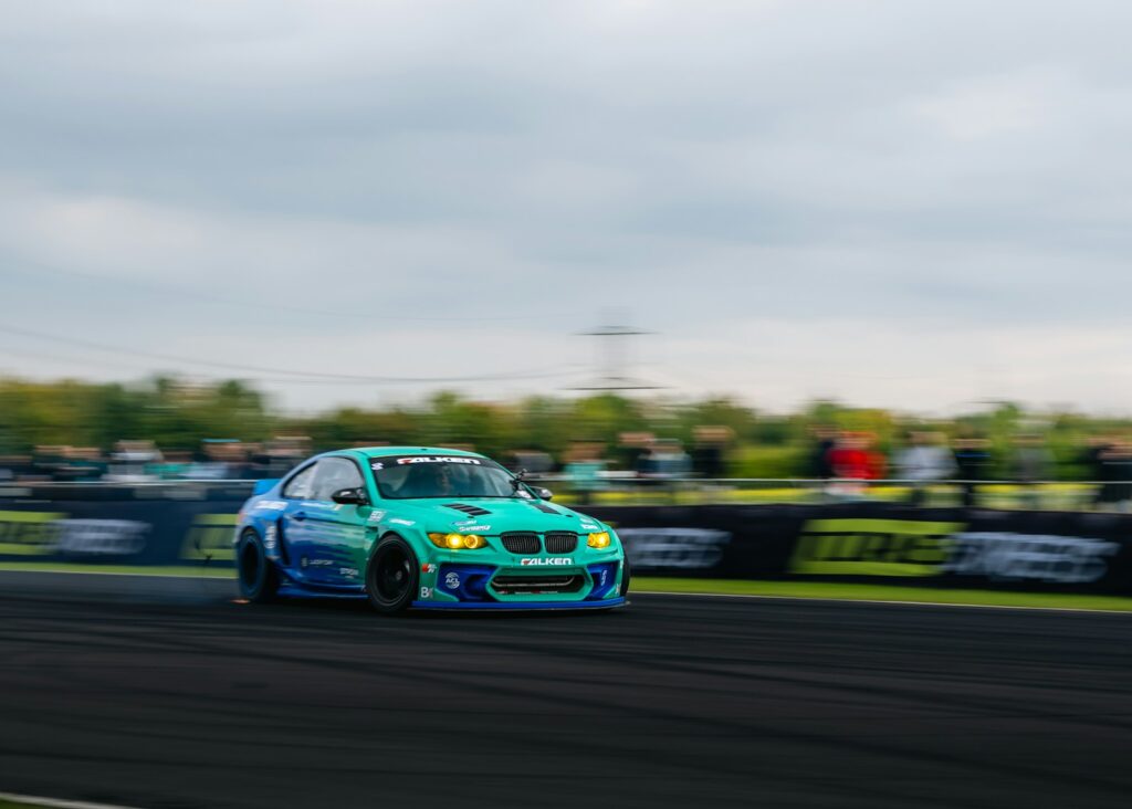 Blue race car speeding on track with blurred background