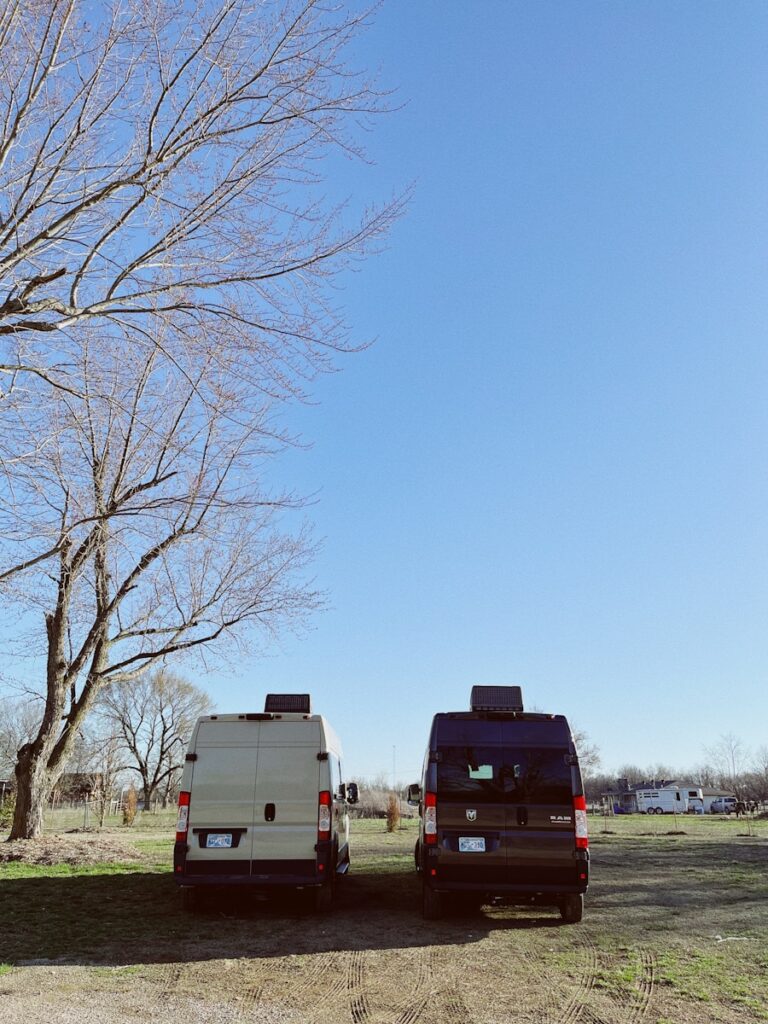 two vans parked next to each other in a field