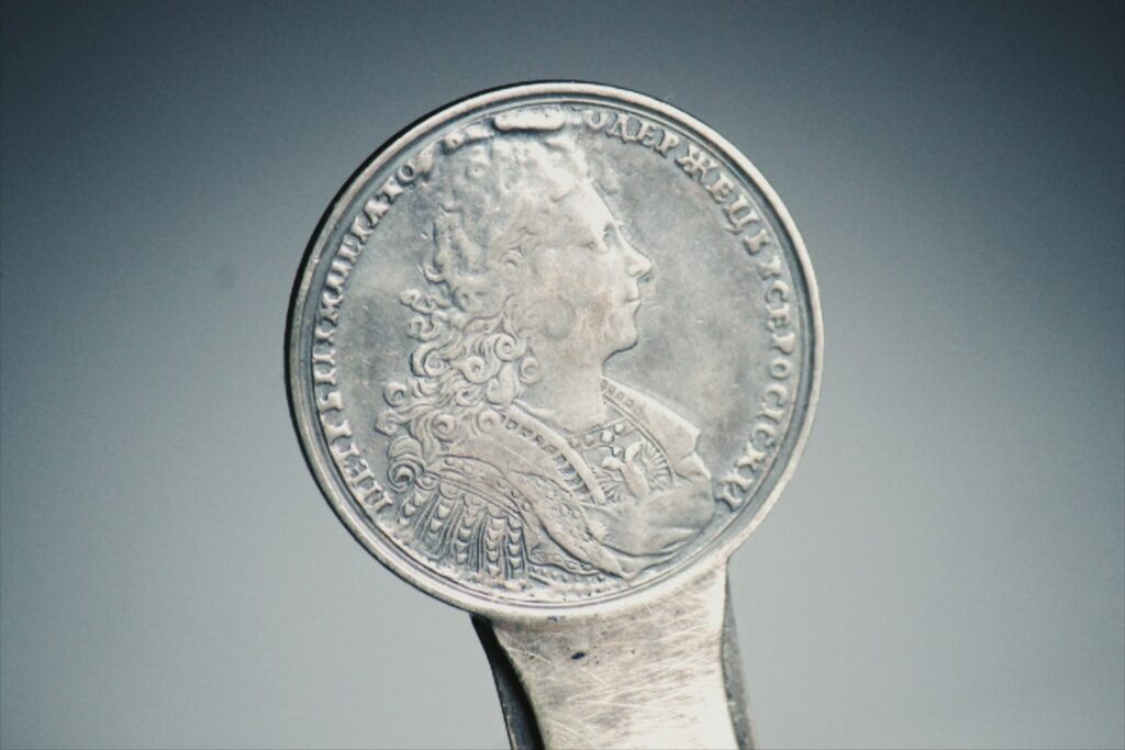 silver round coin on white surface