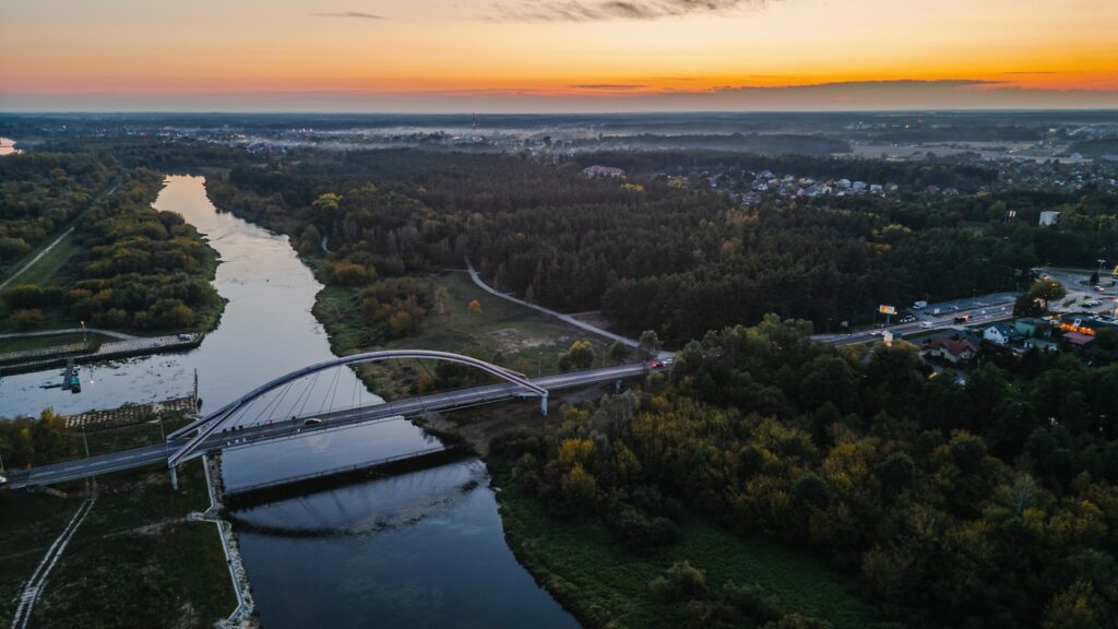 An aerial view of a river and bridge at sunset.