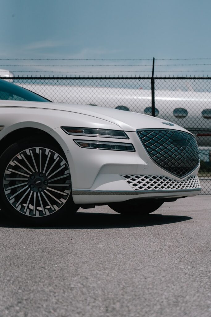 a white car parked in front of a fence
