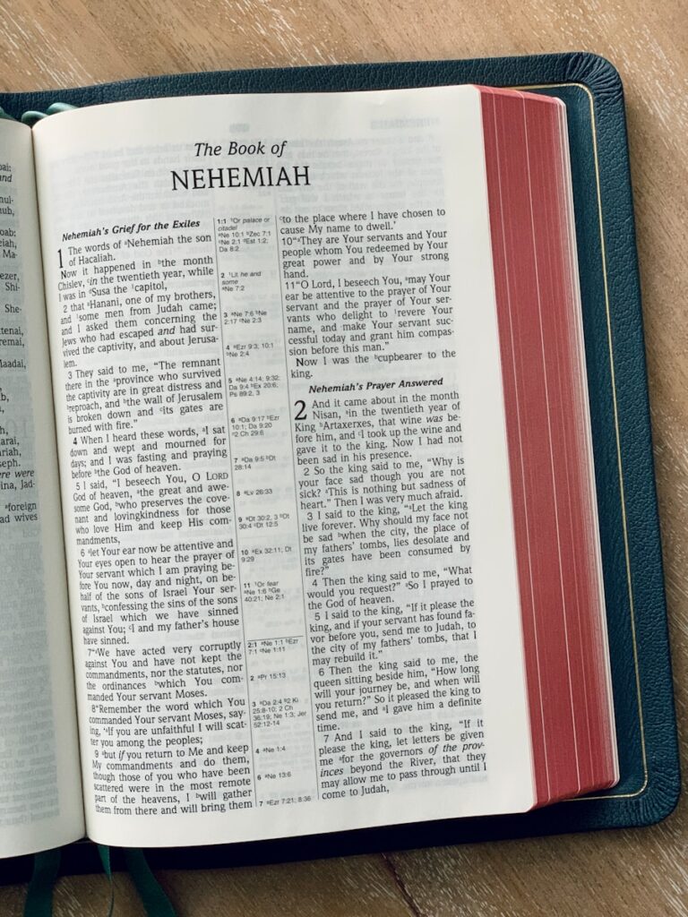 a book of nehemiah on a wooden table