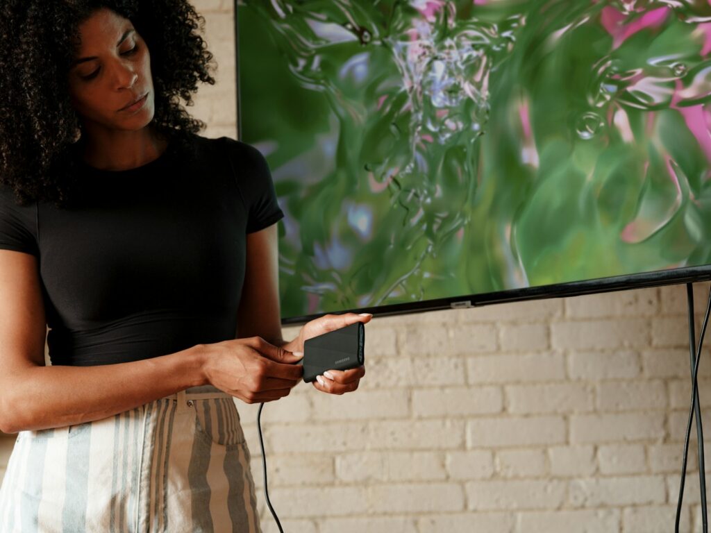 A woman standing in front of a flat screen TV