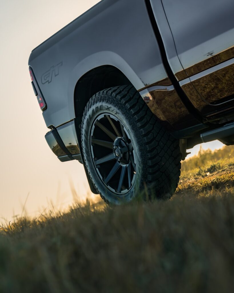 Close-up of a truck wheel on grassy terrain