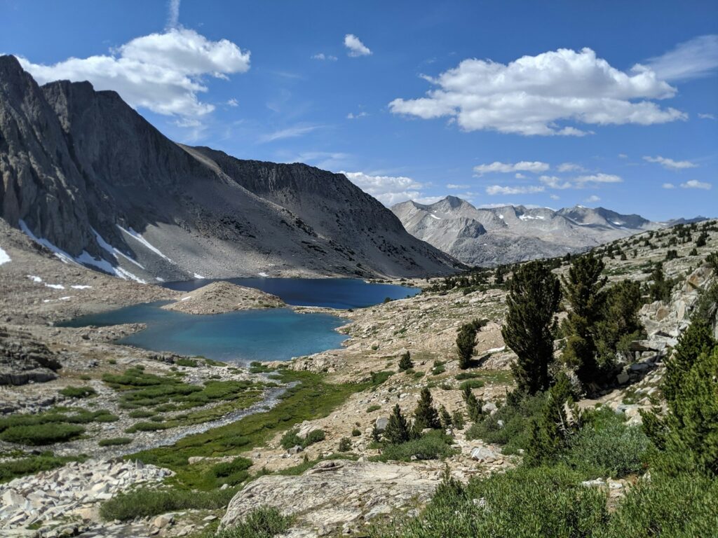 a view of a mountain lake from the top of a hill