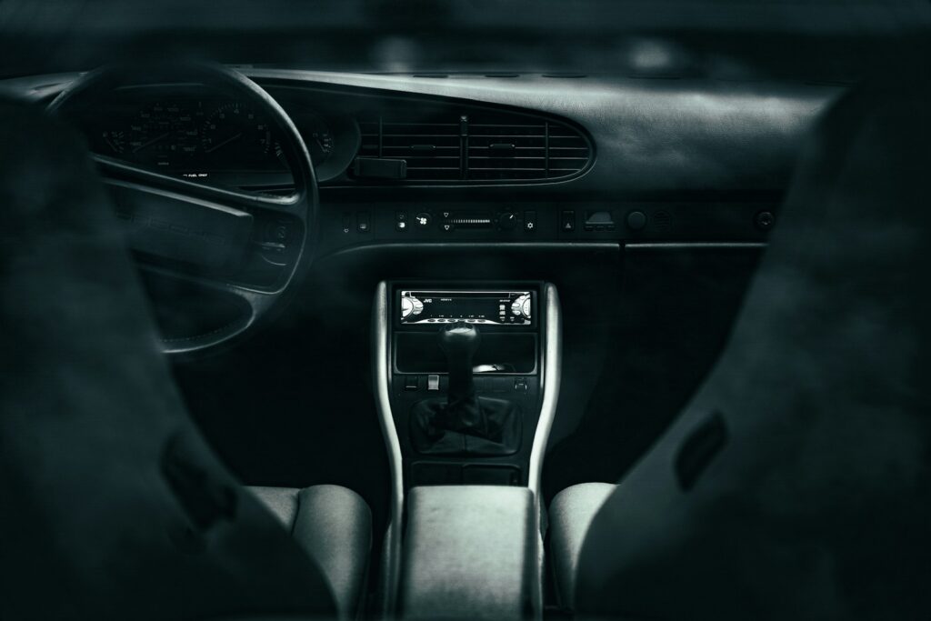 A person sitting in a car with their hands on the steering wheel