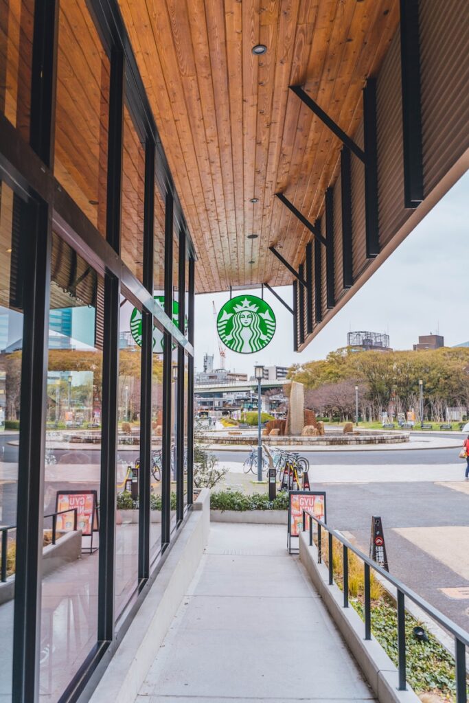 a starbucks sign hanging from the side of a building