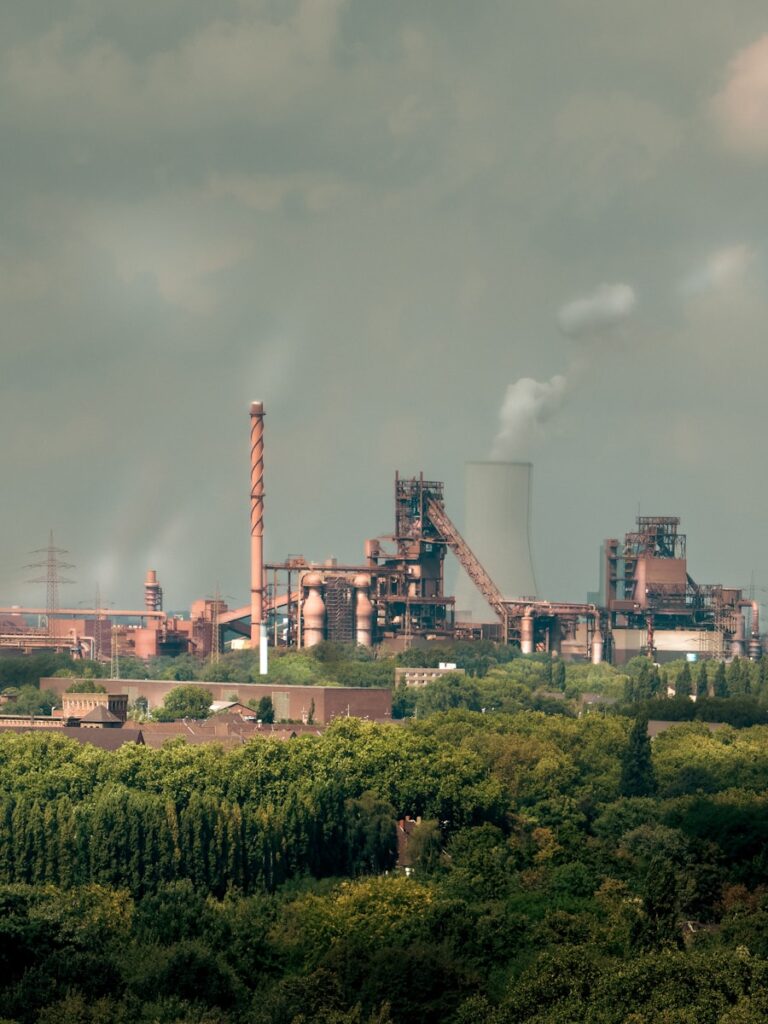 Industrial factory with smokestacks and cooling tower.
