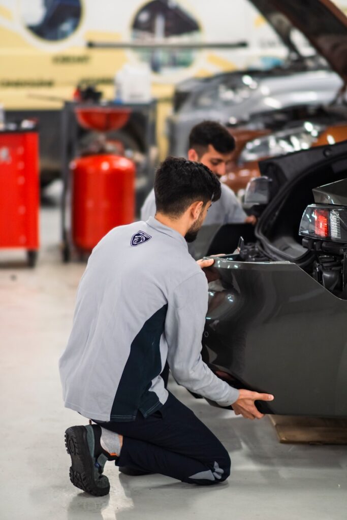 Two men working on a car in a garage