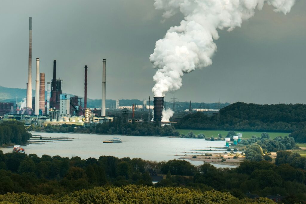 Industrial complex with smoke billowing from stacks.