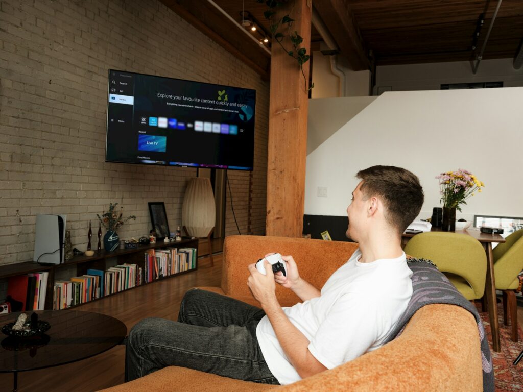 A man sitting on a couch playing a video game