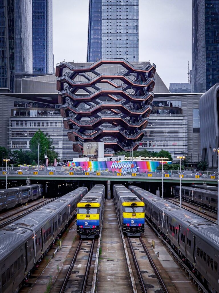 Trains at a station with modern architecture behind