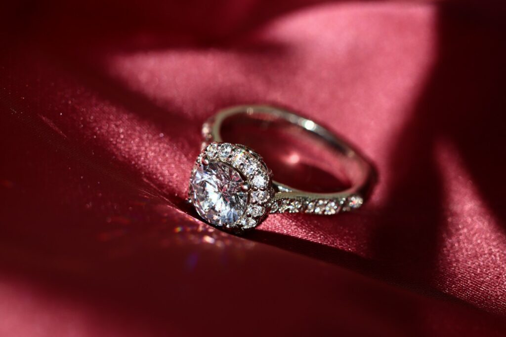 silver diamond ring on red textile