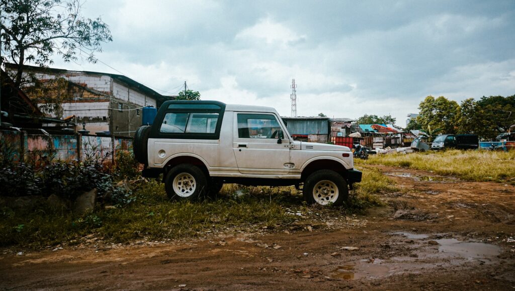 a white truck parked in a field next to a building