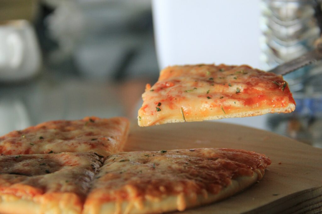a slice of pizza being lifted from a pizza pan