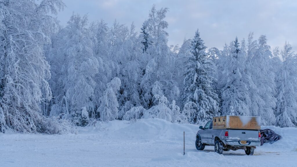 a truck is parked in the middle of a snowy field