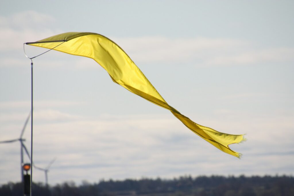 A yellow flag flutters in the wind.