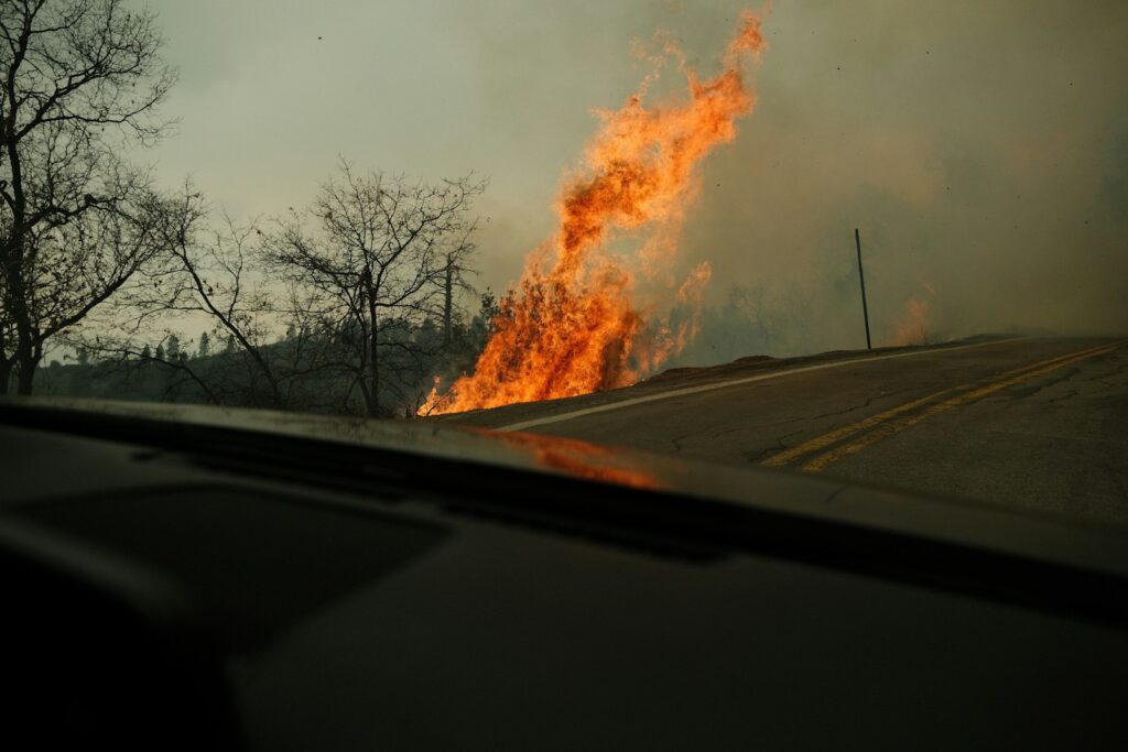 a fire is burning on the side of a road