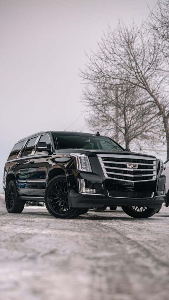 A black cadillac parked in a parking lot