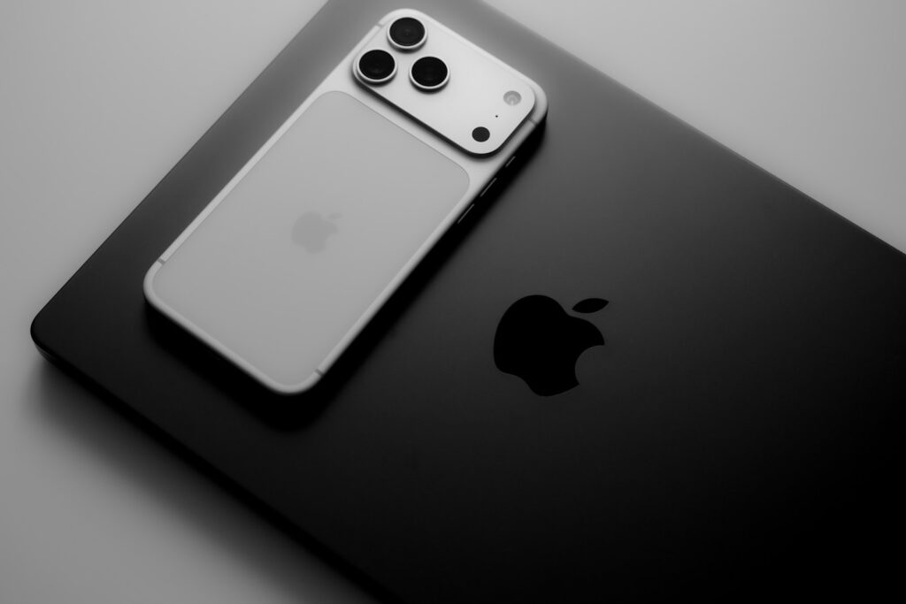 Silver smartphone resting on a black laptop.
