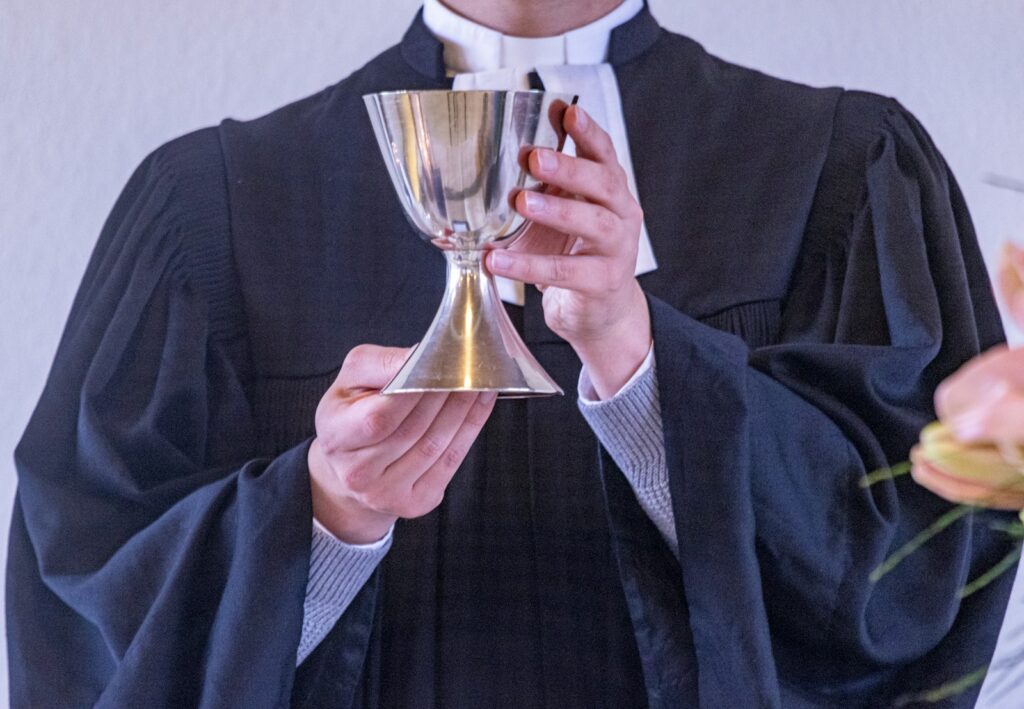 A man in a robe holding a wine glass