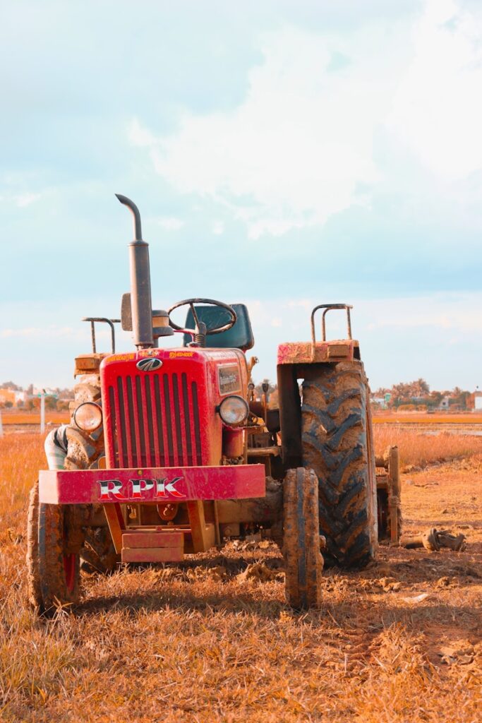 a red tractor is parked in a field