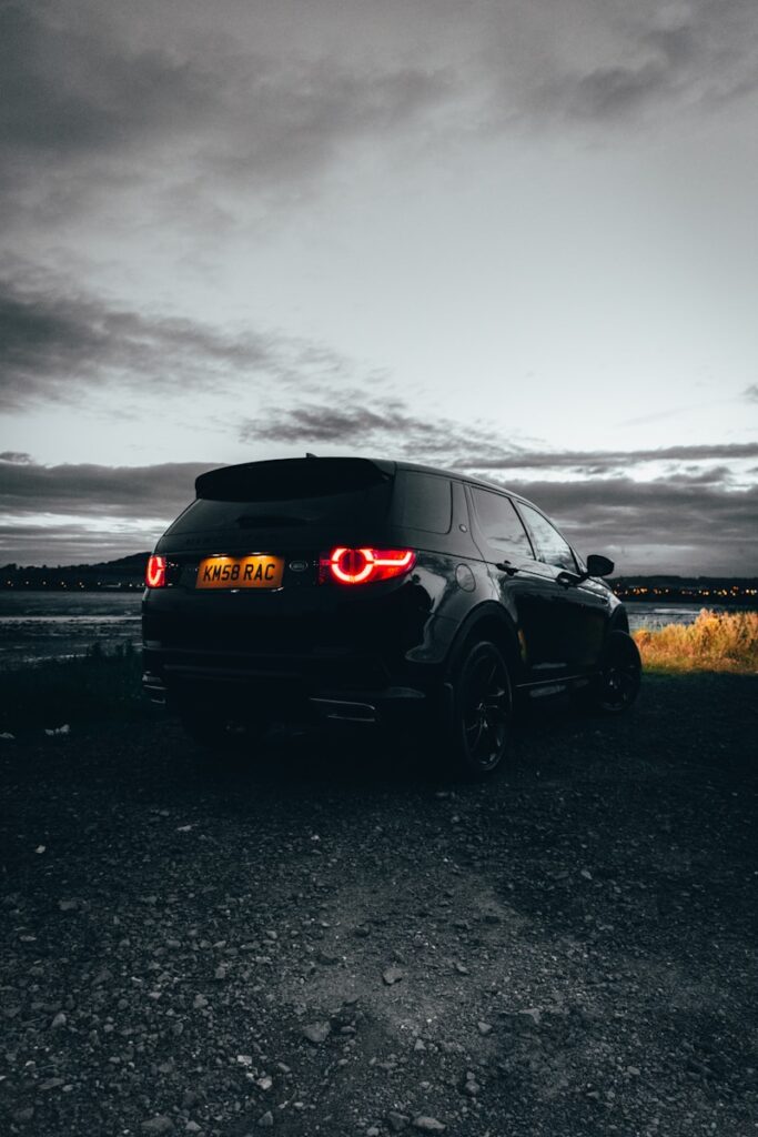 black suv on gray sand under gray sky