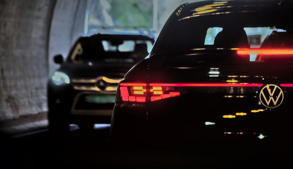 A volkswagen drives through a tunnel, followed by another.