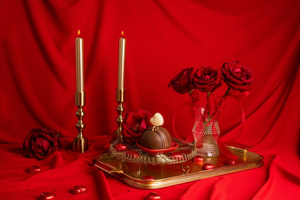 a table topped with a tray covered in chocolates and roses