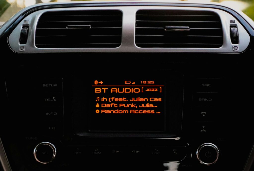 Car stereo displaying bt audio and song information.