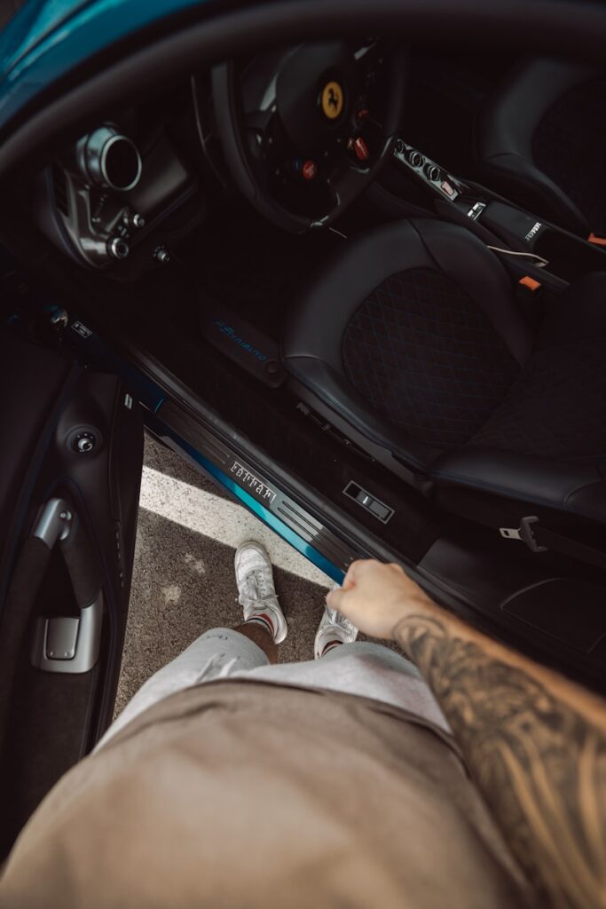 person in brown pants sitting inside car